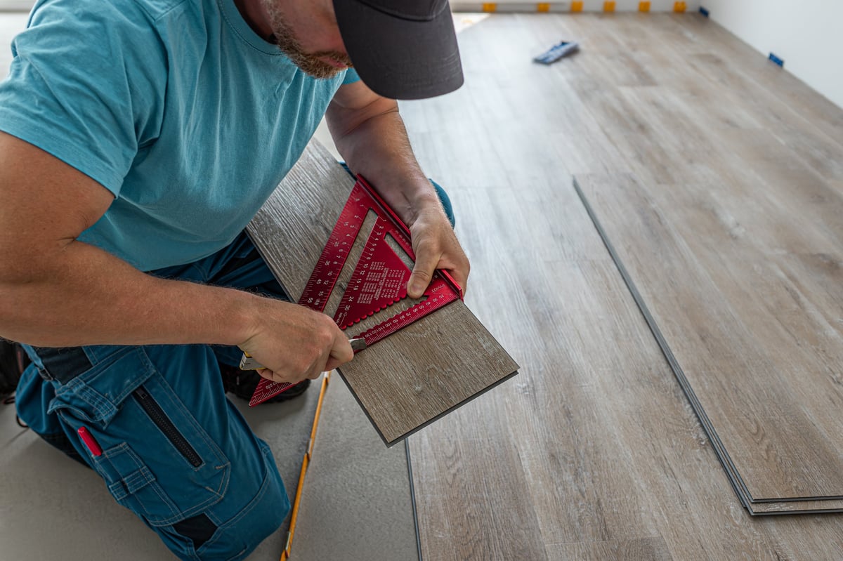Installer cutting vinyl plank to size